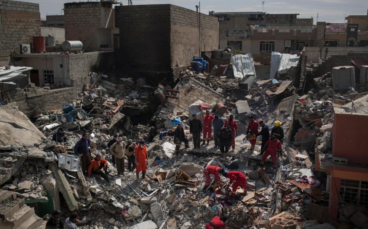 Civil protection rescue teams work on the debris of a house destroyed by an airstrike during fighting between Iraqi security forces and Islamic State militants in Mosul in March - AP