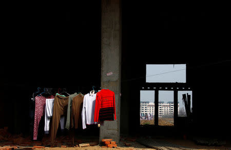 FILE PHOTO: Clothes hang from a line in a residential building under construction in the town of Gushi in Henan Province, March 28, 2010. REUTERS/David Gray/File Photo
