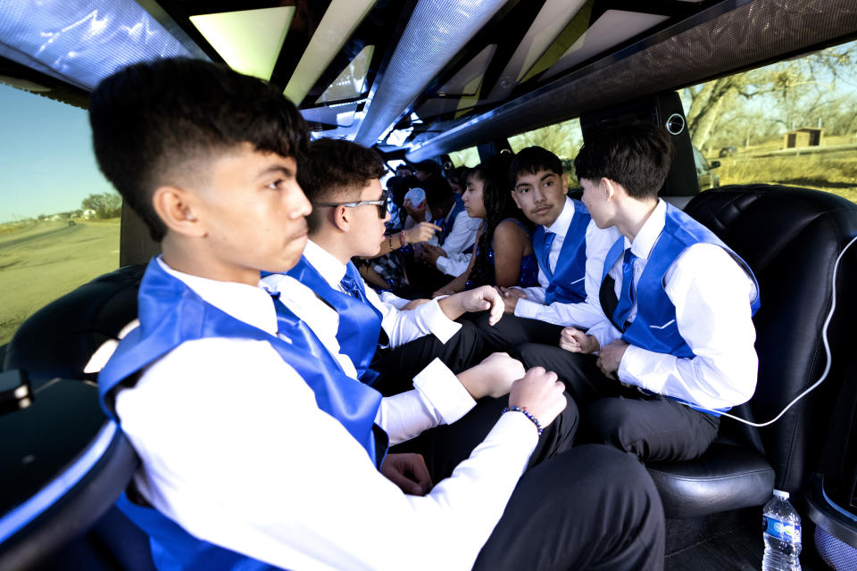 Teenagers participating in a Quinceañera sit in a stretch limousine after posing for photographers at the Rainbow Bridge in the outskirts of Fort Morgan, Colo., Saturday, Dec. 16, 2023. (AP Photo/Julio Cortez)