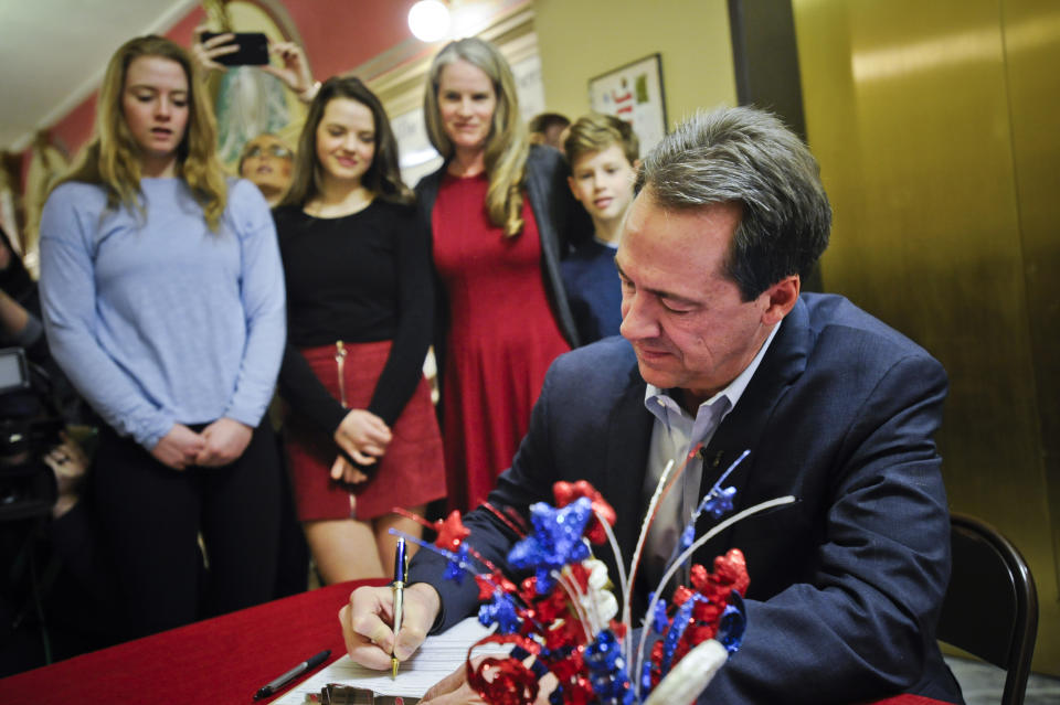 FILE - In this March 9, 2020 file photo with family members looking on, Montana Gov. Steve Bullock files paperwork to run for U.S. Senate against incumbent Republican Sen. Steve Daines in Helena, Mont. (Thom Bridge/Independent Record via AP,File)