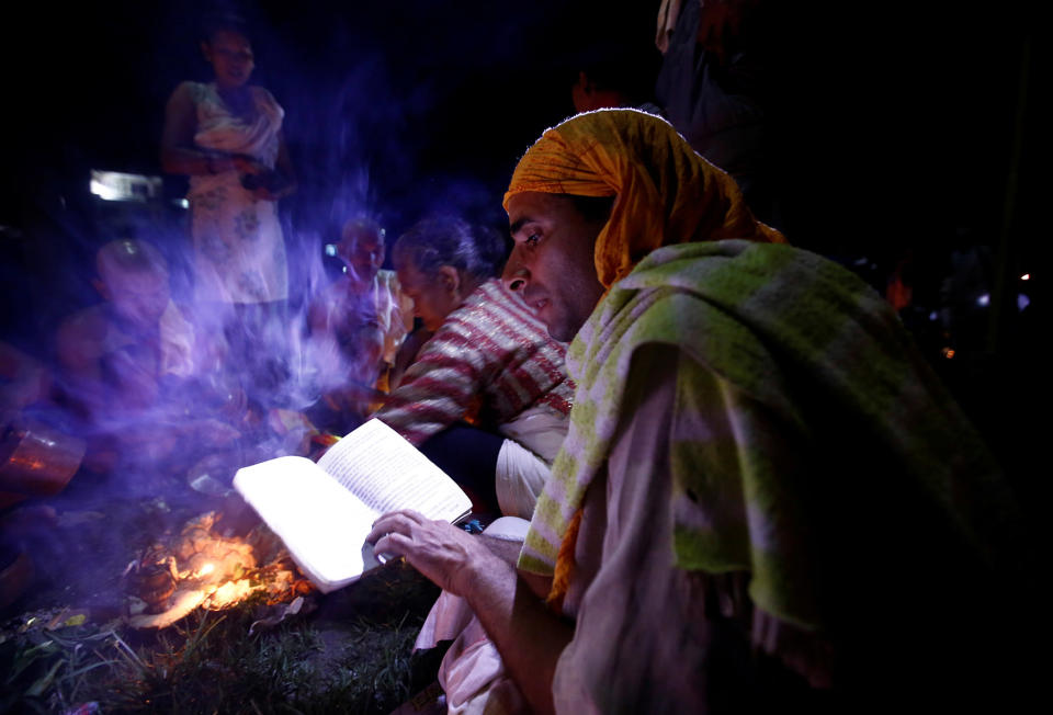 A Hindu priest recites prayers from a holy book while performing a ritual near the bank of Bagmati River during Kuse Aunse (Father’s Day) at Gokarna Temple in Kathmandu