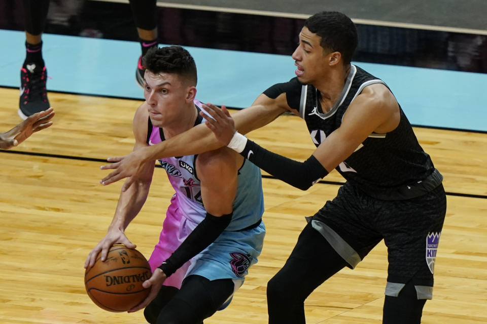 Miami Heat guard Tyler Herro (14) looks to pass the ball under pressure from Sacramento Kings guard Tyrese Haliburton (0) during the first half of an NBA basketball game, Saturday, Jan. 30, 2021, in Miami. (AP Photo/Marta Lavandier)