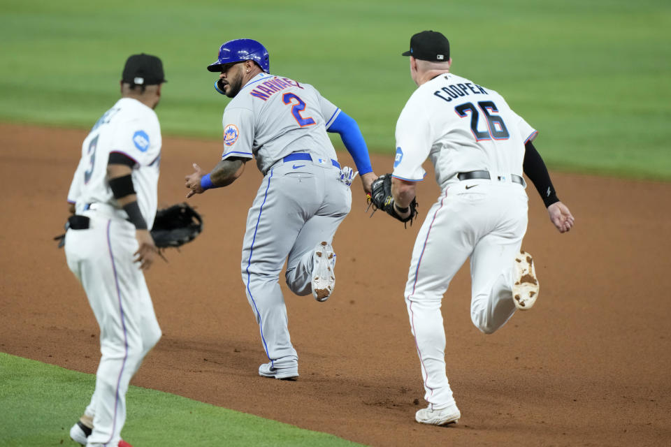 New York Mets' Omar Narvaez (2) is caught in a rundown before being tagged out by Miami Marlins first baseman Garrett Cooper (26) during the third inning of an opening day baseball game, Thursday, March 30, 2023, in Miami. (AP Photo/Lynne Sladky)