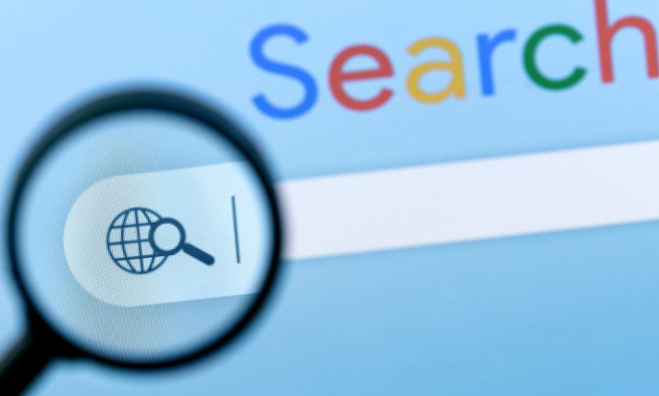 A magnifying glass looking at a search bar on a computer. 