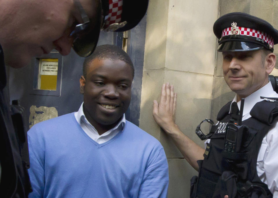 FILE This Friday, Sept. 16, 2011 file photo shows former UBS trader Kweku Adoboli, center, walking to a security van flanked by police officers after appearing at the City of London Magistrates Court in London. A rogue trader who lost $2.2 billion in bad deals at Swiss bank UBS was convicted of fraud on Tuesday, Nov. 20, 2012. Ghanaian-born Kweku Adoboli, 32, exceeded his trading limits and failed to hedge trades, allegedly faking records to cover his tracks at the bank's London office. At one point, Adoboli risked running losses of up to $12 billion. The fraud conviction carries a maximum jail term of 10 years. (AP Photo/Matt Dunham, File)