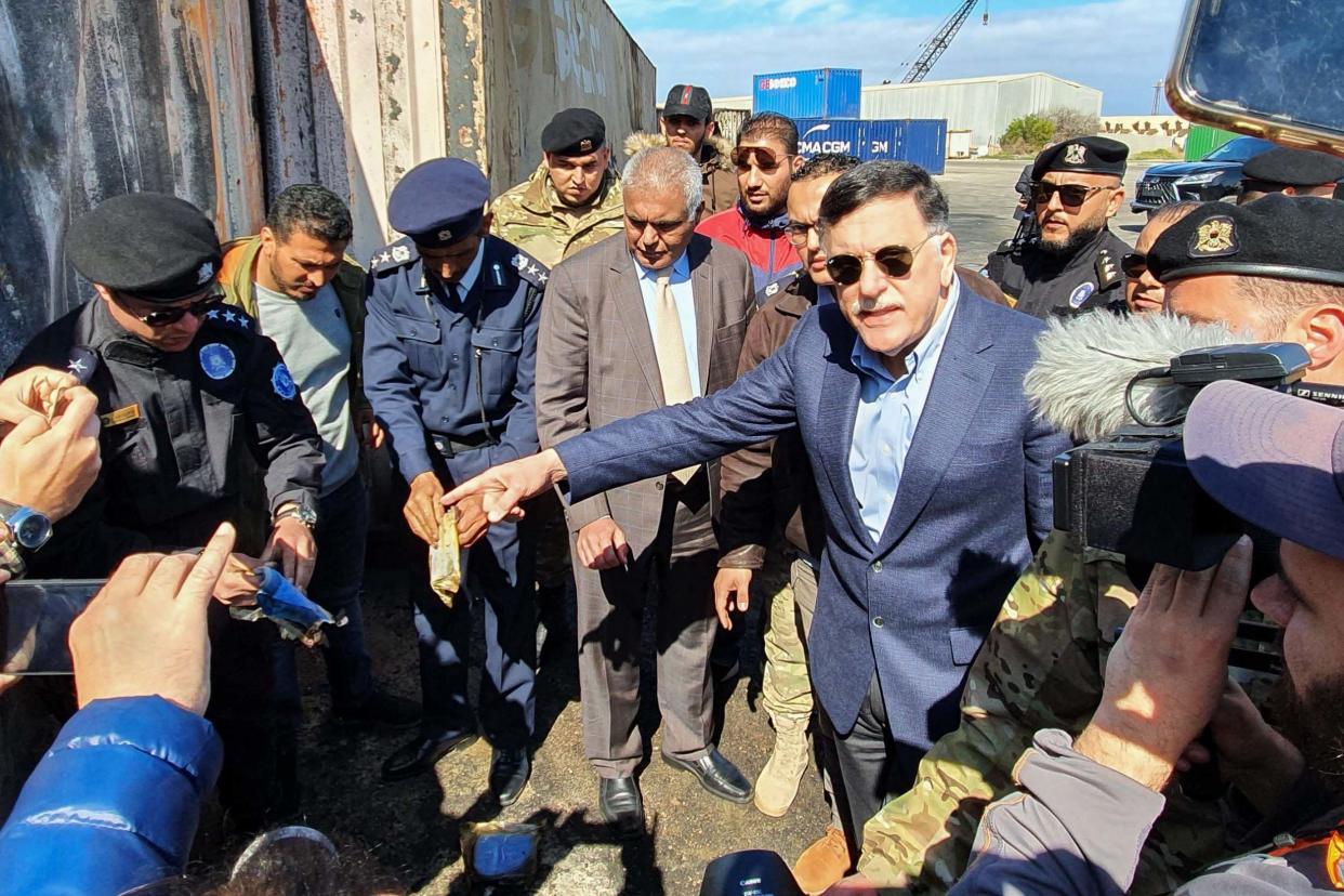 Prime Minister of Libya's UN-recognised Government of National Accord (GNA) Fayez al-Sarraj, flanked by journalists, visits the port in the capital Tripoli after it was hit by rocket fire: AFP via Getty Images