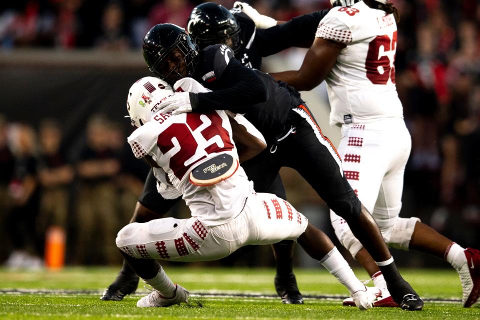 Cincinnati Bearcats defensive lineman Myjai Sanders (21) tackles Temple Owls running back Edward Saydee (23) in the first half of the NCAA football game between the Cincinnati Bearcats and the Temple Owls on Friday, Oct. 8, 2021, at Nippert Stadium in Cincinnati. 