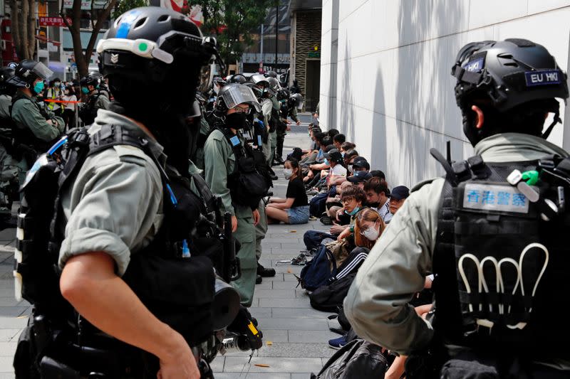 FOTO DE ARCHIVO: Manifestantes antigubernamentales se sientan mientras estaban detenidos durante una protesta en Hong Kong