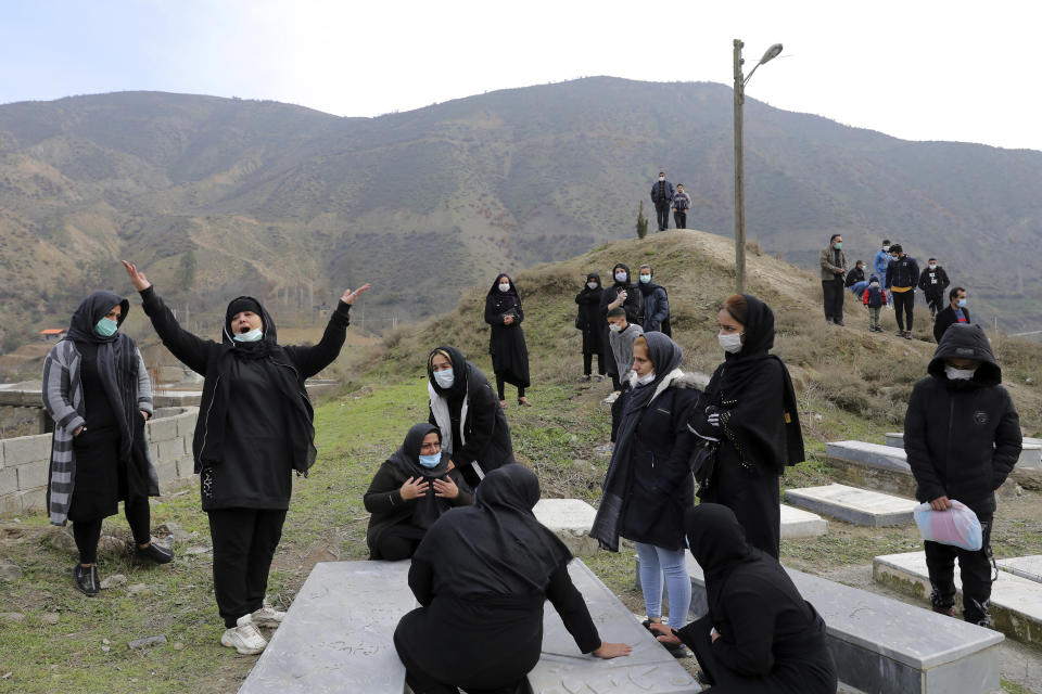 Relatives of Keyumars Ziaee, 60, who died from COVID-19 mourn at a cemetery in the Shir Kola village on the outskirts of the city of Ghaemshahr, in northern Iran, Wednesday, Dec. 16, 2020. (AP Photo/Ebrahim Noroozi)