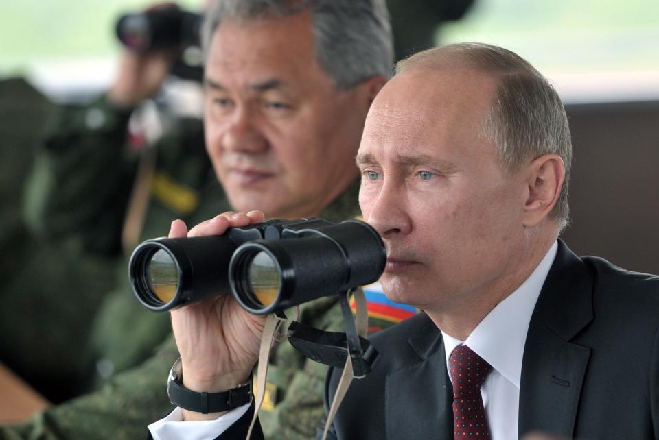 FILE - In this Tuesday, July 16, 2013 file photo Russian President Vladimir Putin, flanked by Defense Minister Sergei Shoigu, uses binocular as he watches military exercise near Yuzhno-Sakhalinsk, on Sakhalin Island, Russia. President Vladimir Putin on Wednesday, Feb. 26, 2014, ordered massive exercises involving most of its military units in western Russia amid tensions in Ukraine. (AP Photo/RIA Novosti, Alexei Nikolsky, Presidential Press Service, Pool)