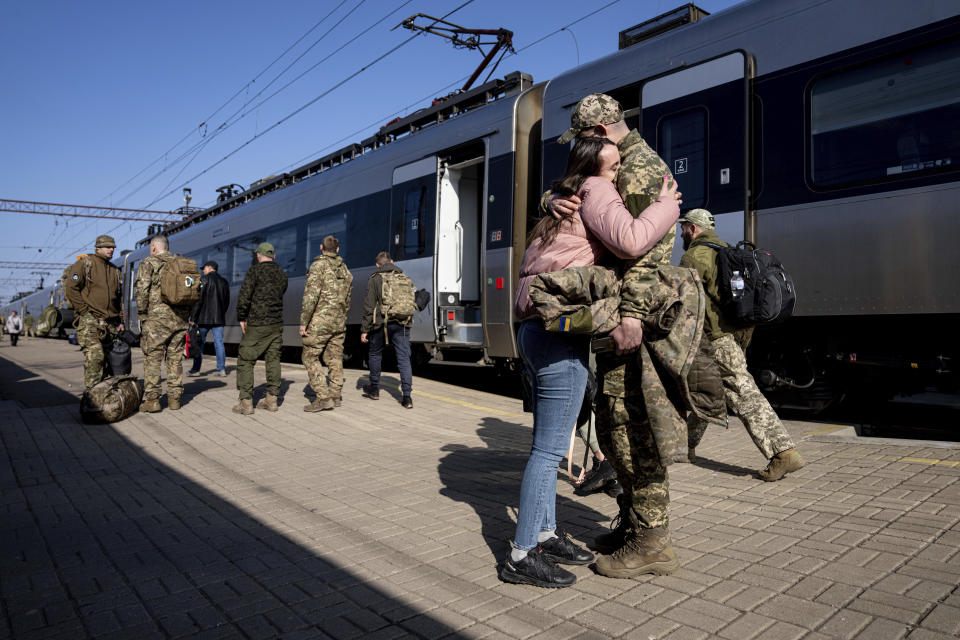 A Ukrainian serviceman hugs his loved one at the train station in Kramatorsk, Ukraine, Thursday, March 23, 2023. (AP Photo/Evgeniy Maloletka)