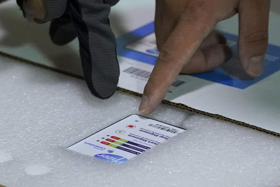 FILE - In this Dec. 15, 2020, file photo, workers point to a sensor in a box of the first shipment of the Pfizer vaccine for COVID-19 as it is opened shortly after it arrived at Madigan Army Medical Center at Joint Base Lewis-McChord in Washington state, south of Seattle. (AP Photo/Ted S. Warren, File)