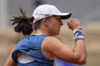 Poland's Iga Swiatek, who plays with a ribbon in the colors of the Ukraine flag on her cap, clenches her fist after scoring a point against Montenegro's Danka Kovinic during their third round match at the French Open tennis tournament in Roland Garros stadium in Paris, France, Saturday, May 28, 2022. (AP Photo/Michel Euler)