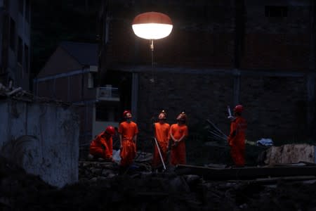 Rescue workers set up a lamp as rescue work continues after typhoon Lekima hit the village in Wenzhou