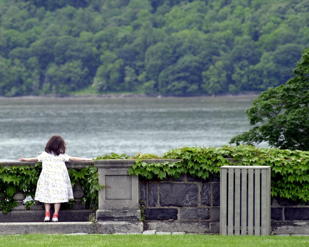 a girl enjoys overlooking the hudson river at wave hill, bro
