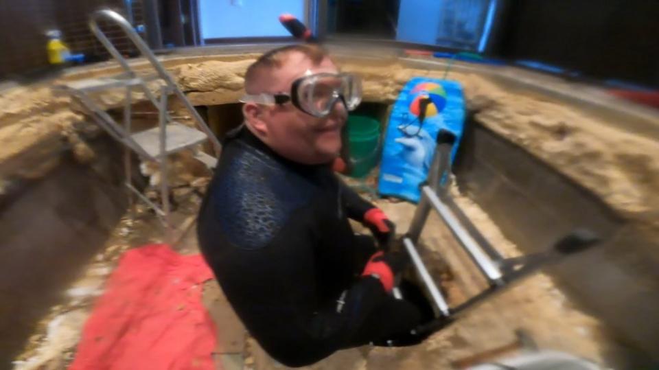 The homeowners probed the hole discovered in their home by scuba diving in the water. Jam Press/@hayleyg099