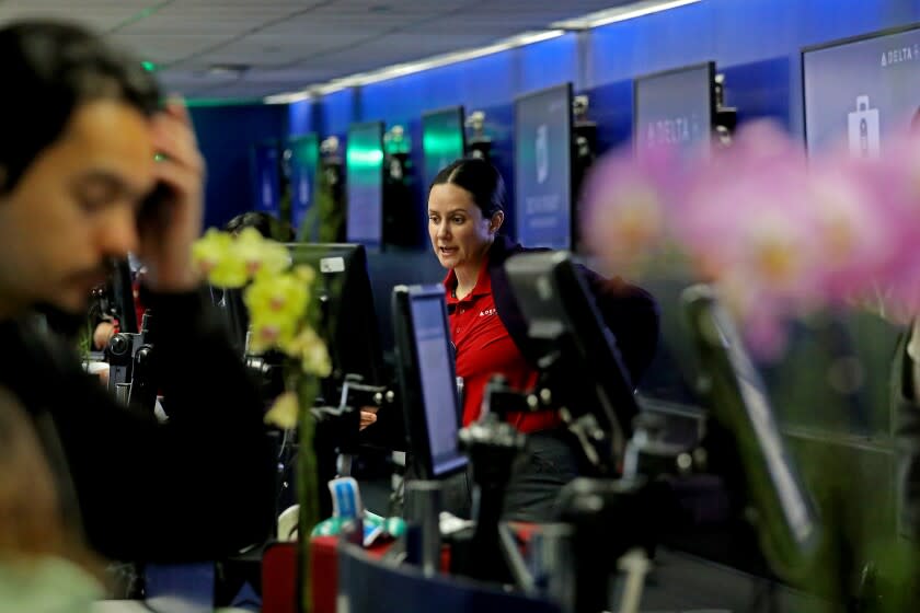 LOS ANGELES, CA - APRIL 19: A ticket agent helps passengers at Delta Airlines Terminal Two at Los Angeles International Airport on Tuesday, April 19, 2022 in Los Angeles, CA. Airports and airlines dropped their mask requirements after a Florida federal judge voided the Biden administration's mask mandate for planes, trains and buses. (Gary Coronado / Los Angeles Times)