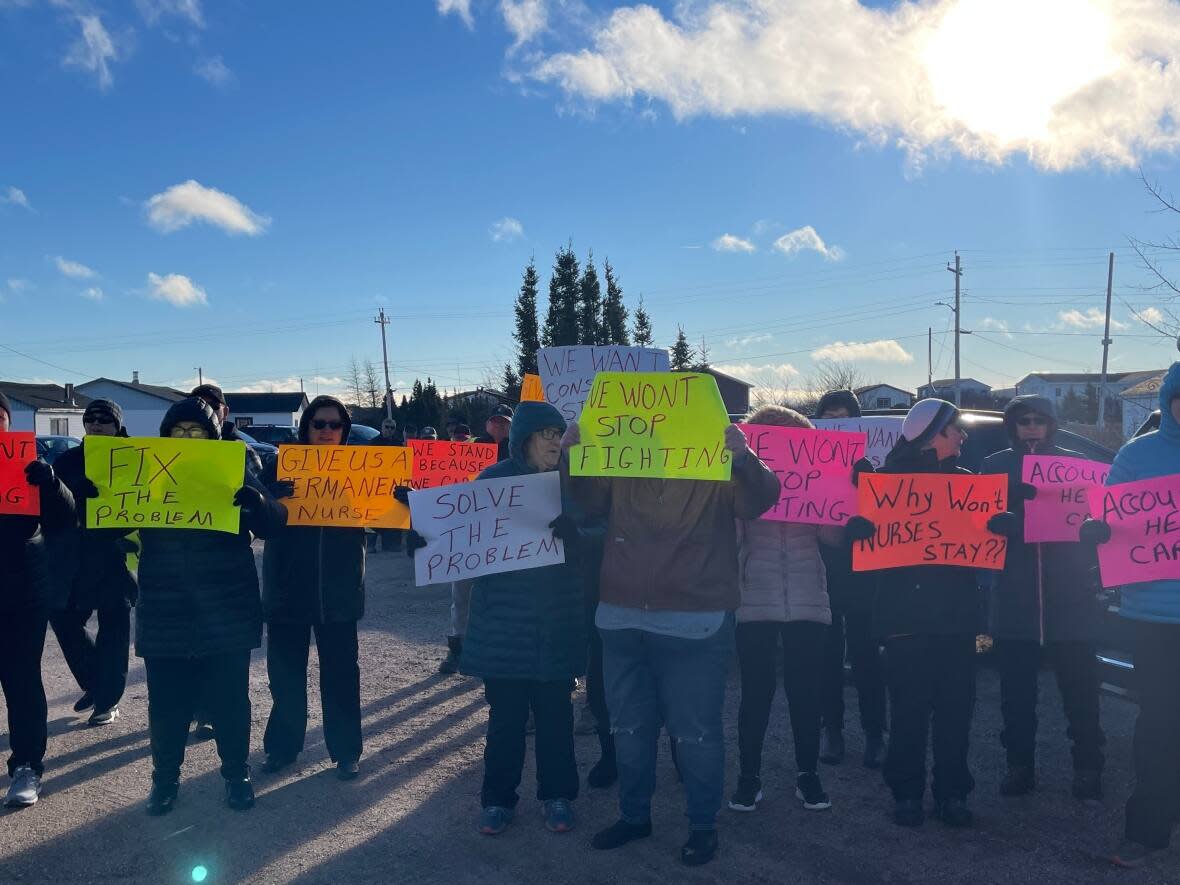 Mary's Harbour and Lodge Bay residents raise their signs as representatives from Labrador-Grenfell Health leave a meeting with town council Monday. (Regan Burden/CBC - image credit)