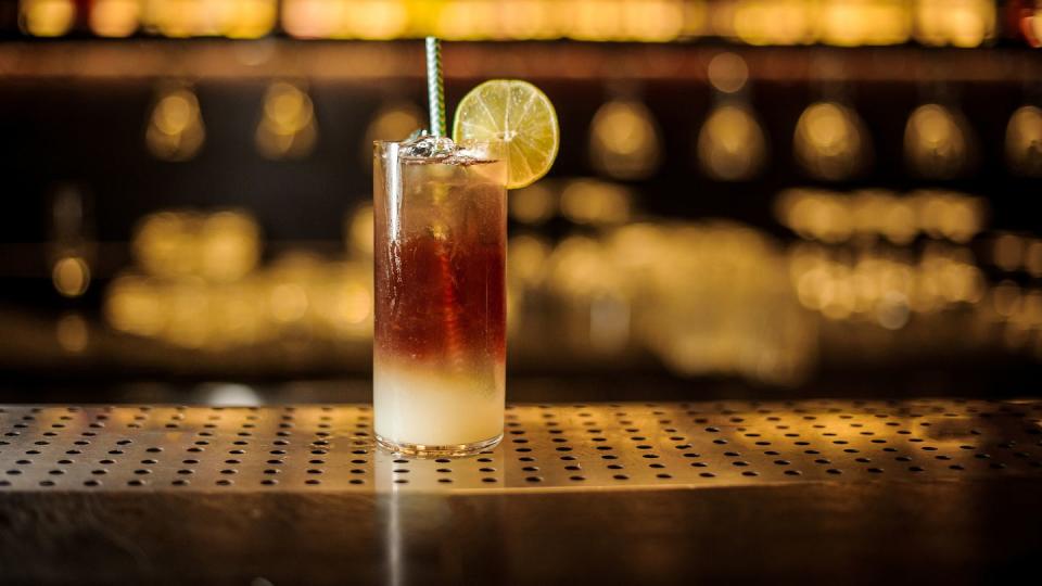 dark stormy cocktail decorated with lime slice on the bar counter