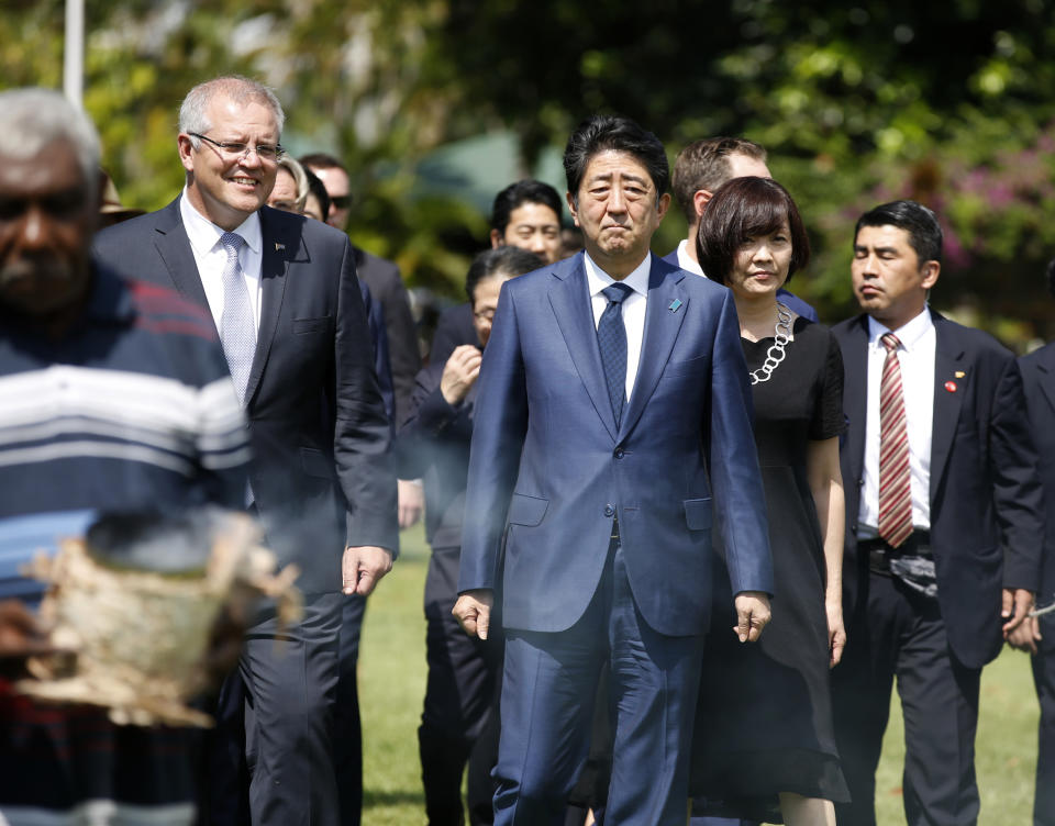 Japanese Prime Minister Shinzo Abe, center, walks with Australian Prime Minister Scott Morrison, left, as they arrive at the Cenotaph War Memorial in Darwin, Australia, Friday, Nov. 16, 2018. Behind Abe is his wife Akie Abe. (Glenn Campbell/Pool Photo via AP)