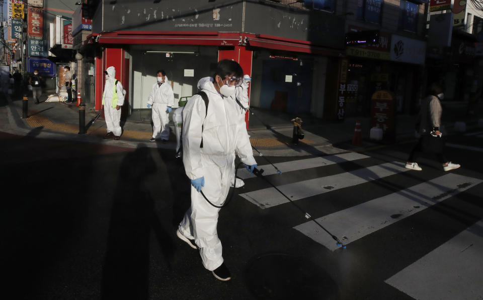 Workers in protective gear spray disinfectant to help curb the spread of the coronavirus in Seoul, South Korea, Tuesday, Oct. 6, 2020. (AP Photo/Lee Jin-man)