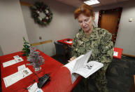 United States Navy Specialist Petty Officer 1st Class Shannon Chambers of Long Beach, Calif., looks over a volunteer playbook in the NORAD Tracks Santa center at Peterson Air Force Base, Monday, Dec. 23, 2019, in Colorado Springs, Colo. More than 1,500 volunteers will answer an estimated 140,000 telephone inquiries to learn of the whereabouts of Santa Claus on Christmas Eve. (AP Photo/David Zalubowski)