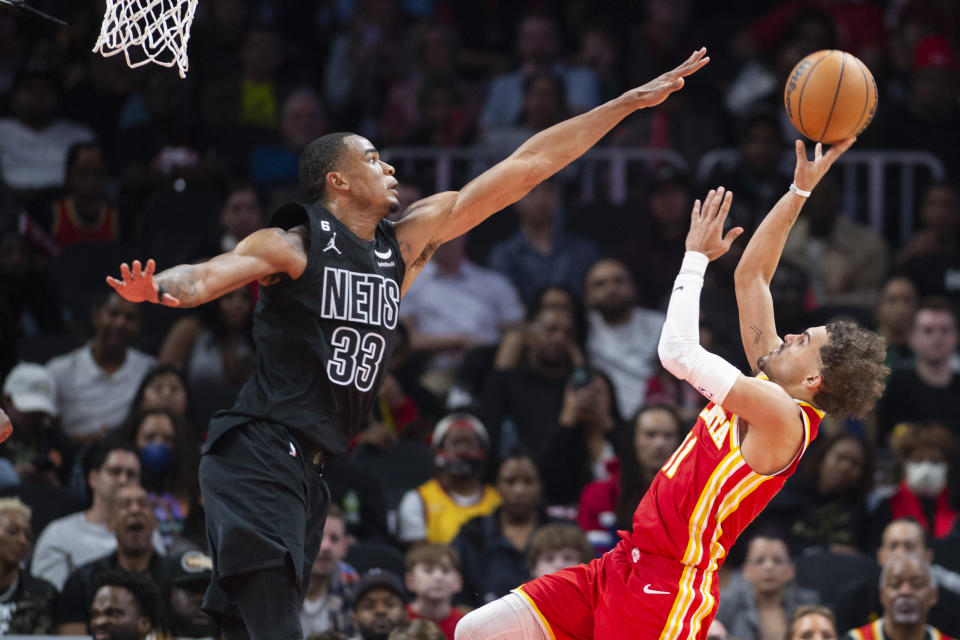 Atlanta Hawks guard Trae Young, right, shoots a floater against Brooklyn Nets center Nic Claxton during the second half of an NBA basketball game, Sunday, Feb. 26, 2023, in Atlanta. (AP Photo/Hakim Wright Sr.)