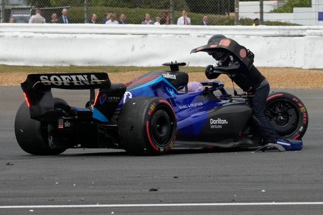 Williams driver Alex Albon is helped from his damaged car