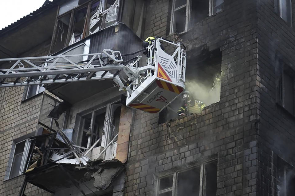 In this photo provided by the Ukrainian Emergency Service, rescuers work the scene of a building damaged by Russian rocket attack in Kharkiv, Ukraine, Tuesday, Jan. 23, 2024. (Ukrainian Emergency Service via AP Photo)