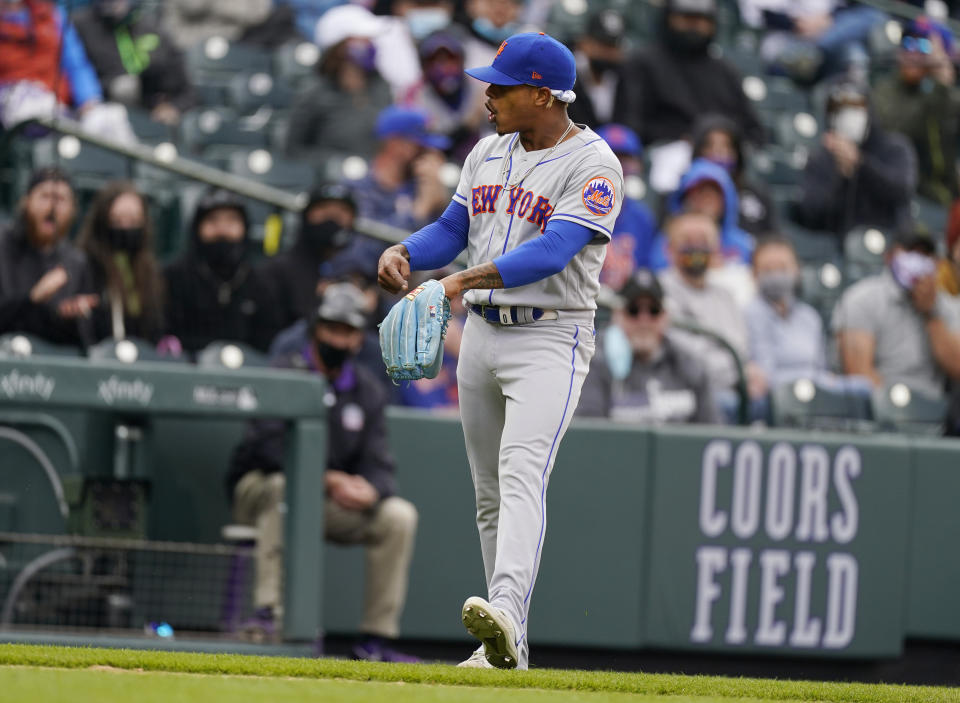 New York Mets starting pitcher Marcus Stroman points to his glove after stopping a ground ball off the bat of Colorado Rockies' Josh Fuentes in the eighth inning of a baseball game Sunday, April 18, 2021, in Denver. (AP Photo/David Zalubowski)