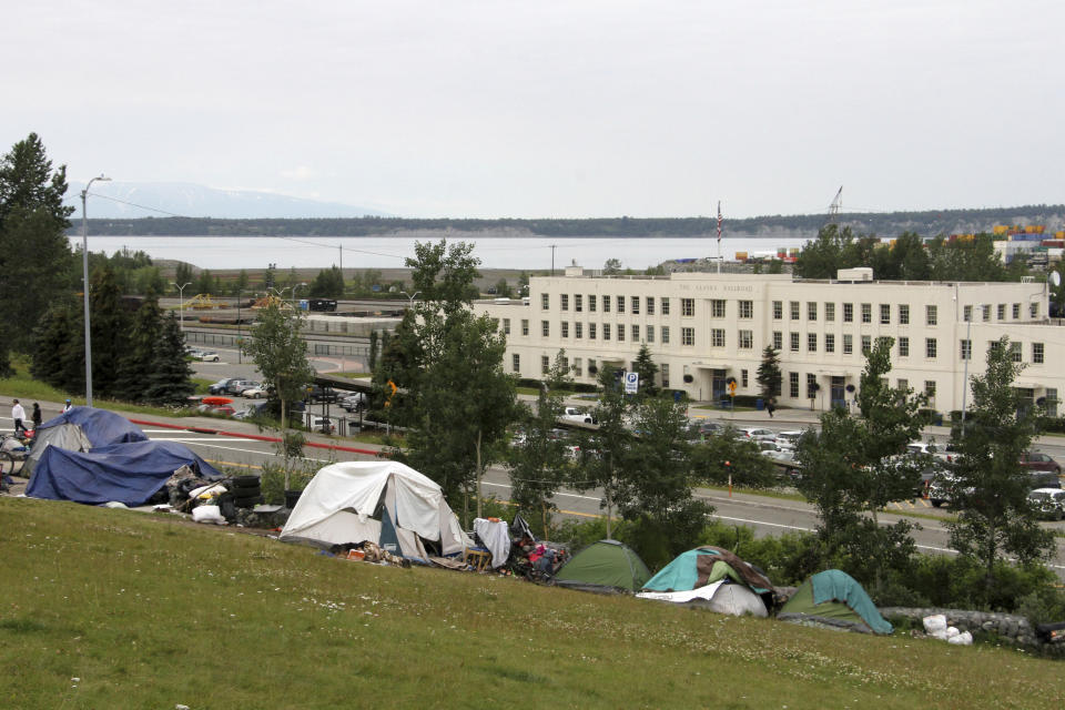 An outdoor tent city for the homeless sits on Wednesday, July, 26, 2023, across from the city's historic railroad depot in downtown Anchorage, Alaska. Anchorage Mayor Dave Bronson announced a proposal last week to buy homeless people plane tickets out of the state or to other Alaska cities to avoid the frigid winter temperatures instead of standing up Anchorage's sports arena as a mass shelter. (AP Photo/Mark Thiessen)