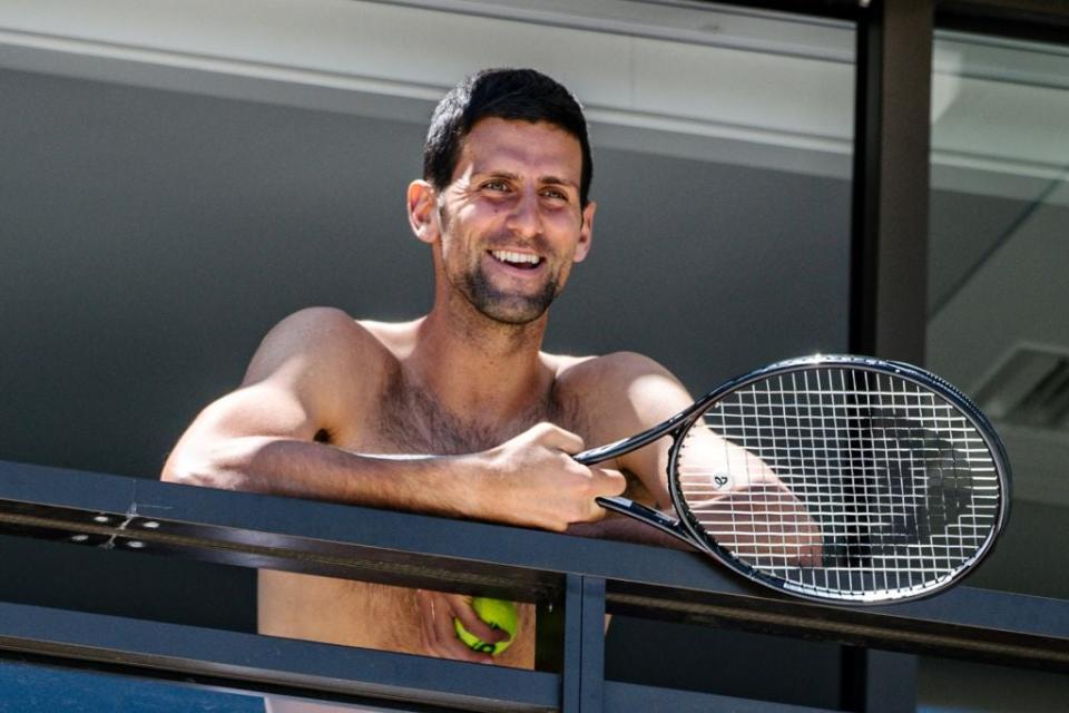 <p>Novak Djokovic smiles at fans from a hotel balcony in Adelaide</p> (Getty)