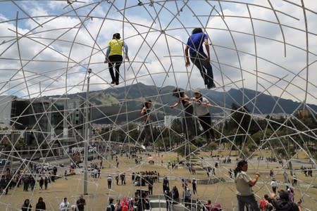 People climb a structure in the aftermath of the last days' protests, after the government of Ecuadorian President Lenin Moreno agreed to repeal a decree that ended fuel subsidies, in Quito