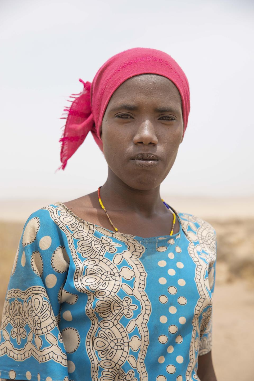 In this July 12, 2019 photo, 18-year-old Raheema Sanu, an Ethiopian migrant, stops for a photograph, about 31 miles (50 kilometers) from Ali Sabeih, Djibouti. She and her brother crossed from Ethiopia. Still early in their journey, they have already trekked through mountains and deserts, in sandstorms and temperatures over 113 degrees. (AP Photo/Nariman El-Mofty)