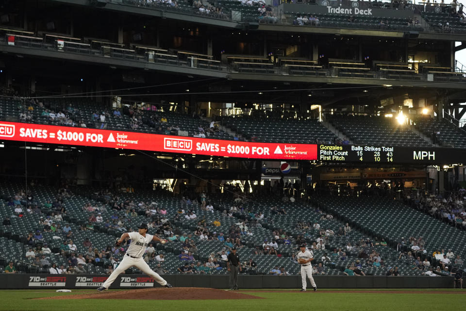 The setting sun shines through the stands as Seattle Mariners starting pitcher Marco Gonzales throws to an Oakland Athletics batter during the fourth inning of a baseball game Tuesday, June 1, 2021, in Seattle. (AP Photo/Ted S. Warren)