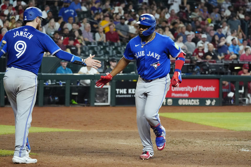 Toronto Blue Jays' Vladimir Guerrero Jr., right, celebrates his home run against the Arizona Diamondbacks with Blue Jays' Danny Jansen (9) during the seventh inning of a baseball game, Sunday, July 14, 2024, in Phoenix. (AP Photo/Ross D. Franklin)