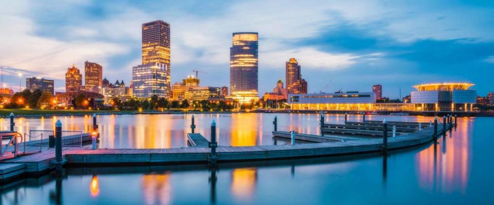 milwaukee skyline at night with reflection in lake michigan.