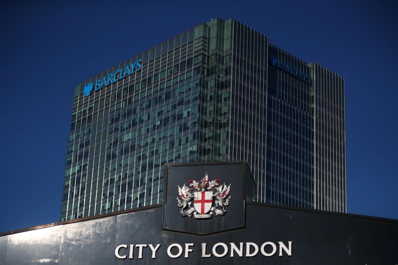 Barclays' building in Canary Wharf is seen behind a City of London sign outside Billingsgate Market in London