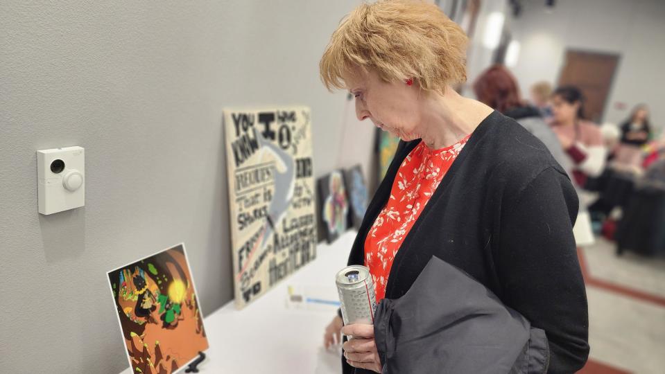A woman admires a local artist's interpretation of a child's drawing Friday night at the HeART of CASA fundraiser in downtown Amarillo.