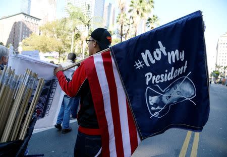 Protesters hold up signs during a march and rally against the United States President-elect Donald Trump in Los Angeles, California, U.S. December 18, 2016.REUTERS/Kevork Djansezian