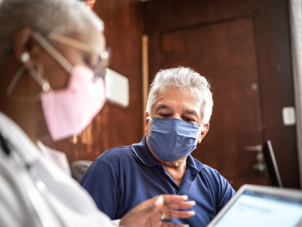 Doctor talking to senior male patient in a home visit