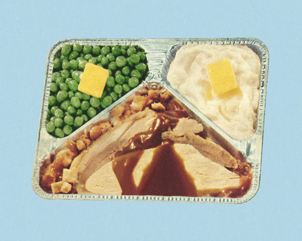 A vintage-style TV dinner tray with compartments of peas with a butter pat, mashed potatoes with a butter pat, and slices of turkey with gravy