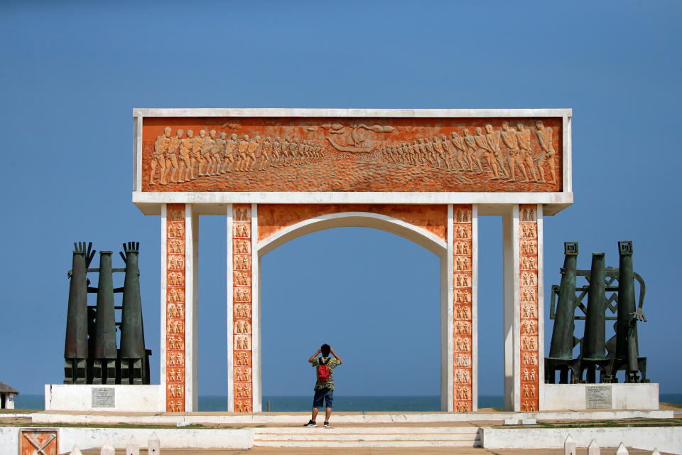 A man takes a photo beneath the monument at the site of the 'Point of No Return' where slaves were loaded onto ships in the historic slave port of Ouidah, Benin. (Photo: Afolabi Sotunde/Reuters)