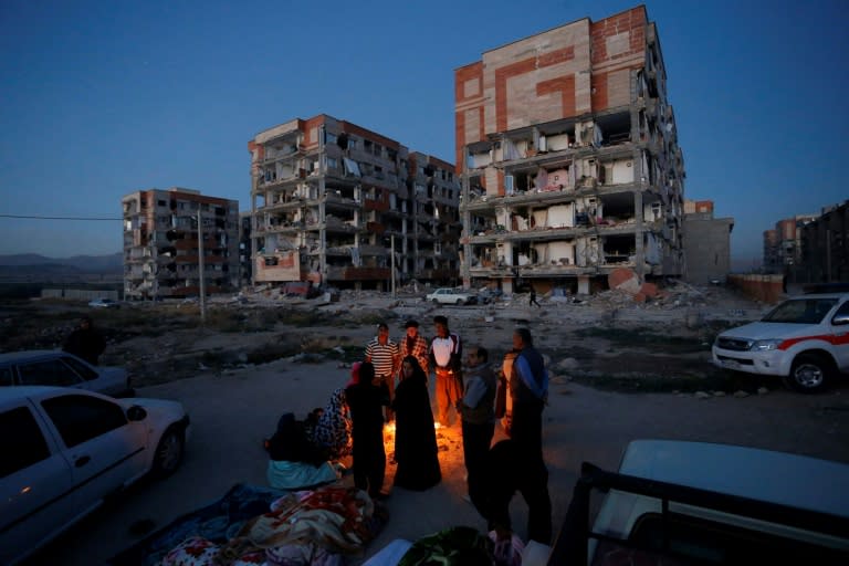 Quake survivors huddle by a fire as temperatures drop in Sar-e Pol-e Zahab in western Iran