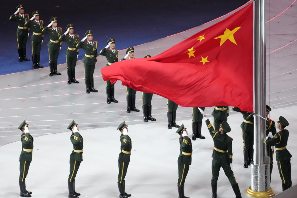 Military salute at the Chinese flag during the opening ceremony of the 19th Asian Games in Hangzhou, China, Saturday, Sept. 23, 2023. (AP Photo/Eugene Hoshiko)