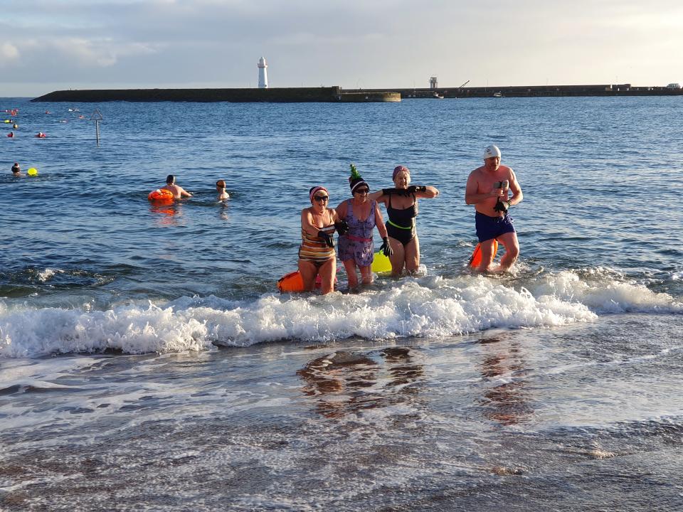 Members of the Donaghadee Chunky Dunkers take part in a swimming competition on Christmas Day in Co. town centre (Rebecca Black/PA)