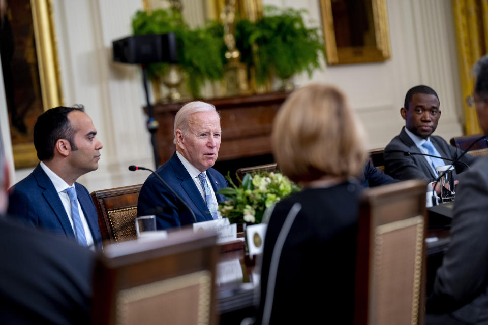President Joe Biden, center, accompanied by Consumer Financial Protection Bureau director Rohit Chopra, left, and Deputy Treasury Secretary Wally Adeyemo, right, speaks at a meeting in the East Room of the White House in Washington, Feb. 1, 2023. Adeyemo says sanctions and export controls imposed by the U.S. and its allies have degraded Russia’s ability to replace more than 9,000 pieces of military equipment lost in the war in Ukraine. (AP Photo/Andrew Harnik, File)