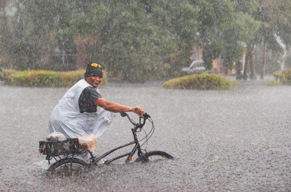 Leon rides his bike down a flooded street in the Edgewood neighborhood on Thursday, April 13, 2023, in Fort Lauderdale, Fla. A torrential downpour severely flooded streets partially submerging houses and cars across South Florida.
