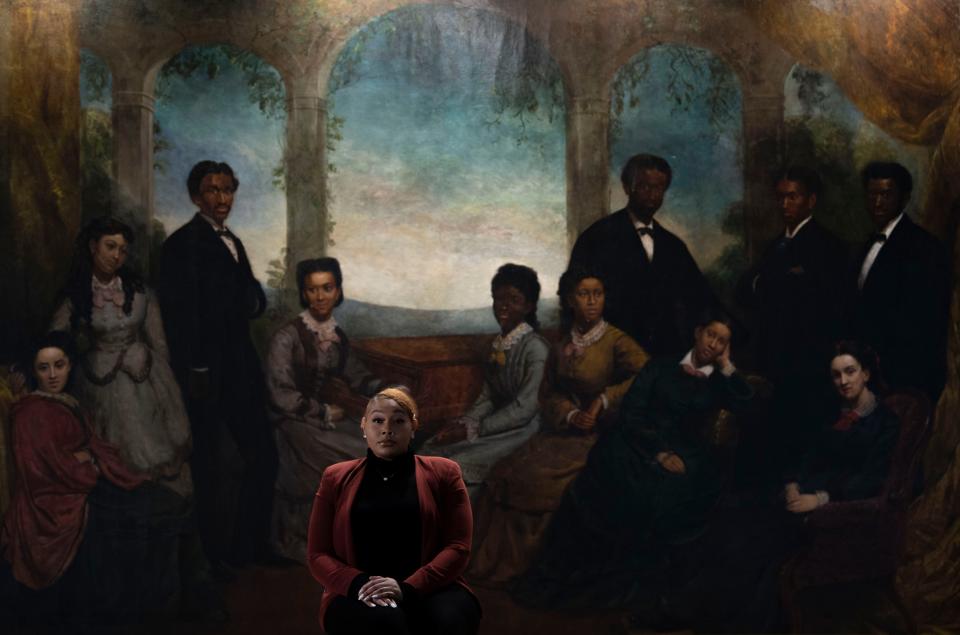 Jada Spight poses for a portrait Feb. 15, 2022, in Jubilee Hall in front of a mural of the Fisk jubilee Singers