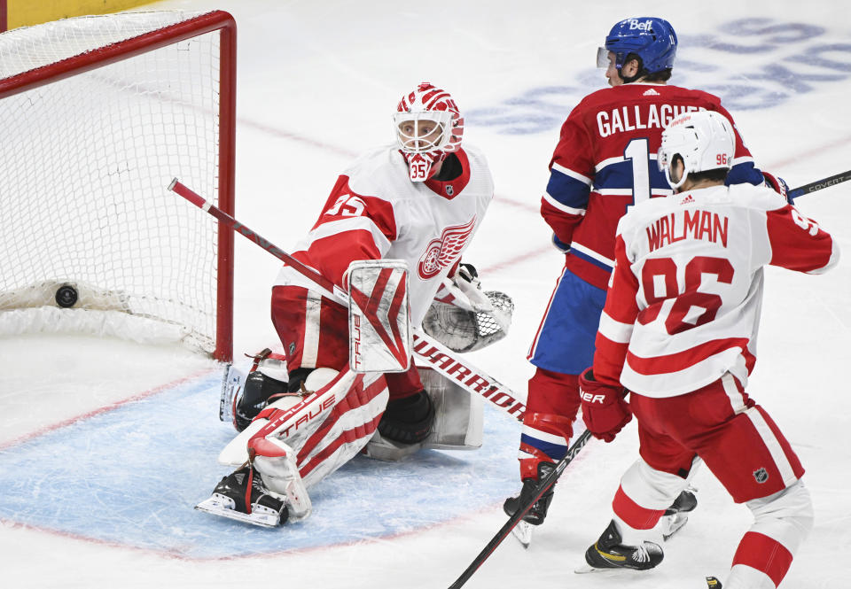 Detroit Red Wings goatender Ville Husso (35) is scored on by Montreal Canadiens' Nick Suzuki (not shown) as Canadiens' Brendan Gallagher and Red Wings' Jake Walman (96) look for a rebound during the third period of an NHL hockey game, Saturday, Dec. 2, 2023 in Montreal. (Graham Hughes/The Canadian Press via AP)